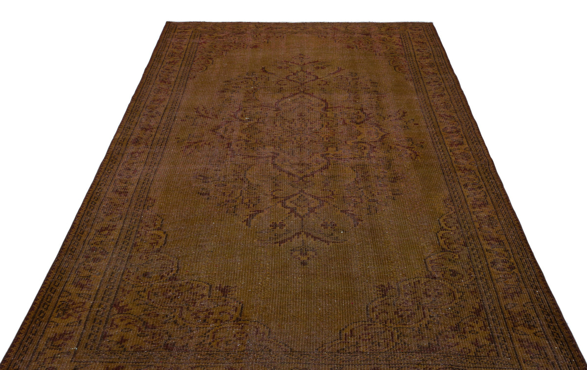 Distressed brown traditional rug with a central floral medallion and ornate border on a white background.
