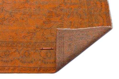 Load image 1 in gallery view. Burnt orange rug with a faded traditional pattern, showing the textured brown backing and a single orange crayon.