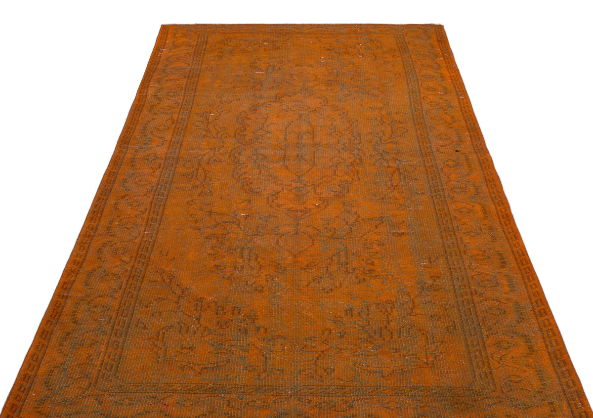 Burnt orange vintage-style rug with a faded central medallion and intricate border pattern on a white background.
