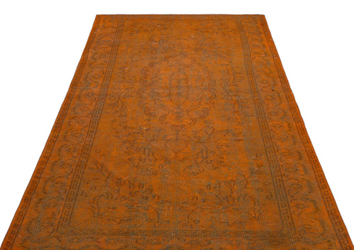 Load image 1 in gallery view. Burnt orange vintage-style rug with a faded central medallion and intricate border pattern on a white background.