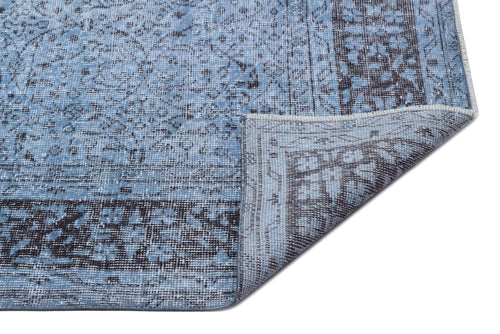 Load image 1 in gallery view. Blue and charcoal grey distressed rug with a traditional medallion pattern, shown with a corner folded over.