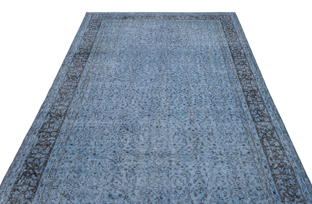 Blue and charcoal grey traditional rug with a distressed floral medallion pattern and a wide decorative border.