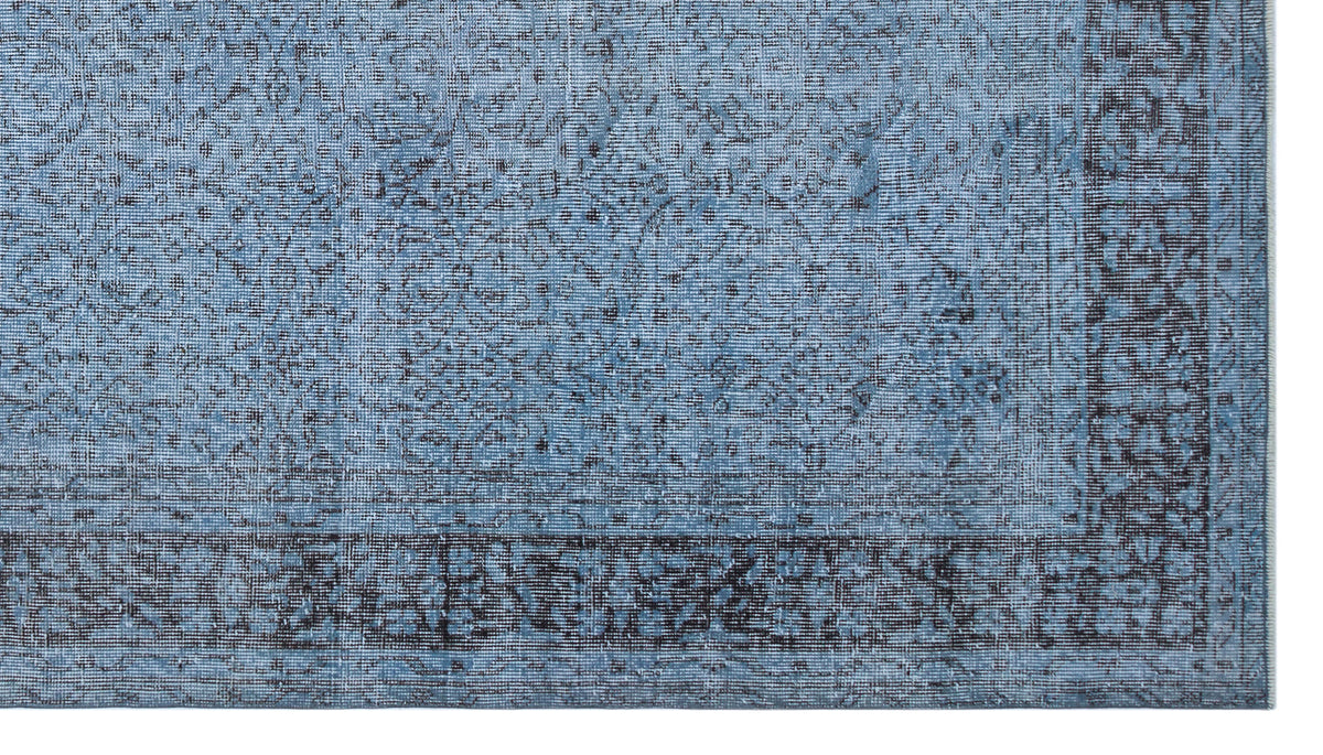 Blue and charcoal distressed traditional rug with a faded floral medallion pattern and a wide decorative border.