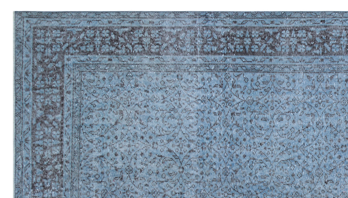 Blue and charcoal grey rug with a distressed traditional floral medallion pattern and a detailed border.