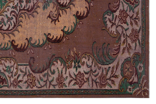 Load image 1 in gallery view. Brown traditional rug with a tan central medallion and intricate floral border in green, beige, and dark brown.