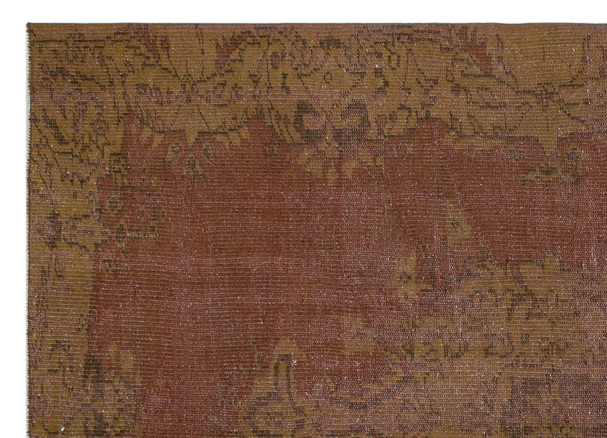 Distressed rust and mustard yellow vintage-style rug with a faded floral medallion border.