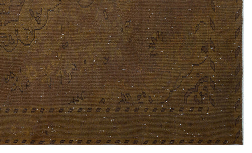 Load image 1 in gallery view. Dark brown distressed rug with a faint, traditional geometric border and scattered white flecks.