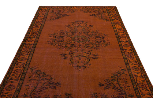 Load image 1 in gallery view. Rust-colored rug with a central dark floral medallion and a decorative border on a white background.