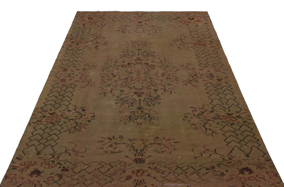 Brown vintage-style rug with a central floral medallion and geometric border pattern on a white background.