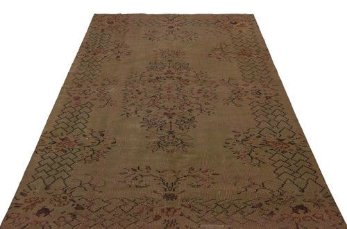 Load image 1 in gallery view. Brown vintage-style rug with a central floral medallion and geometric border pattern on a white background.