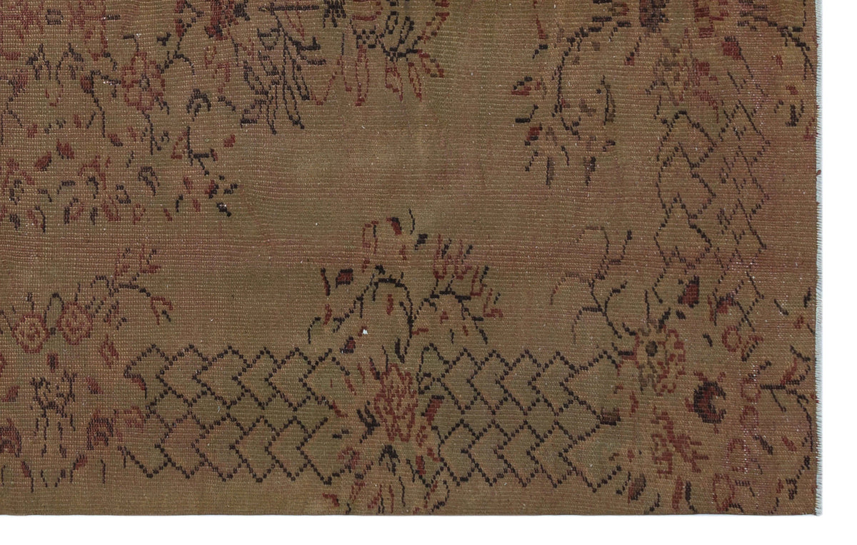 Brown vintage rug with a faded floral pattern and dark geometric border accents.