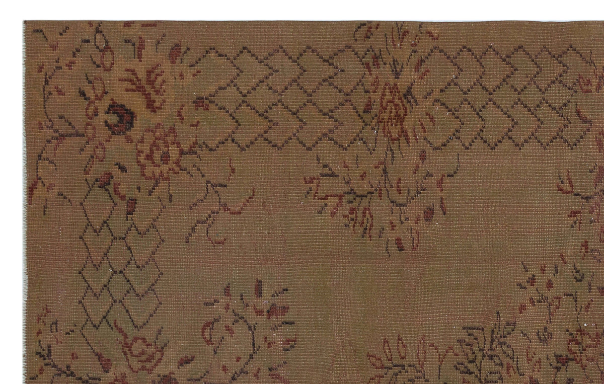 Brown vintage-style rug with a dark red floral motif and a geometric diamond border pattern.