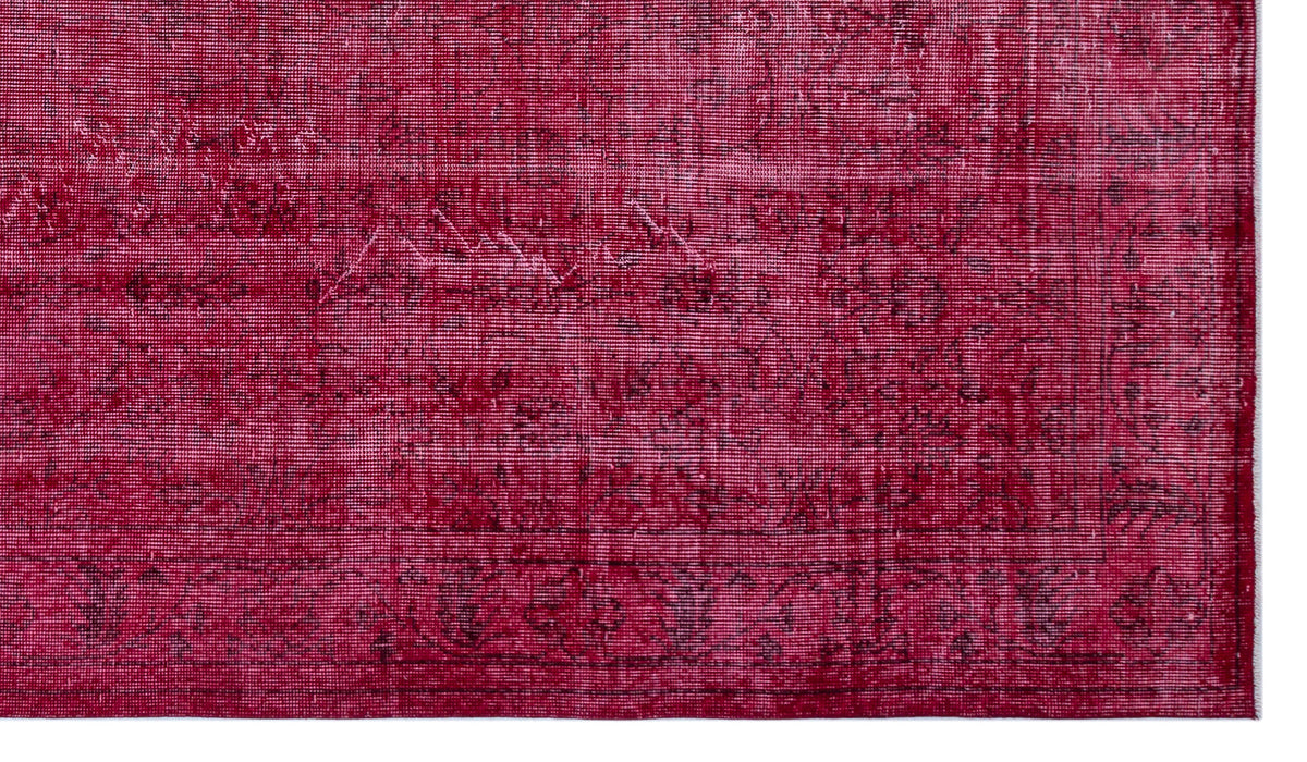 Deep crimson vintage-style rug with a distressed, faded traditional border and central medallion pattern.