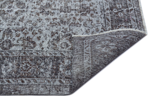 Load image 1 in gallery view. Grey and charcoal distressed rug with a traditional floral medallion pattern, shown with a corner folded over.