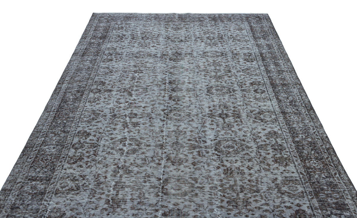 Charcoal and light grey distressed rug with a traditional ornate floral medallion pattern and a wide border.
