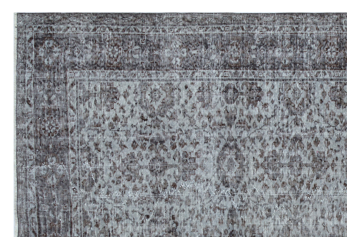 Charcoal and light grey distressed rug with a traditional ornate medallion pattern and a detailed border.