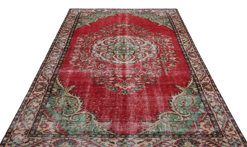 Load image 1 in gallery view. Distressed red Persian-style rug with a central cream and green floral medallion and ornate border.