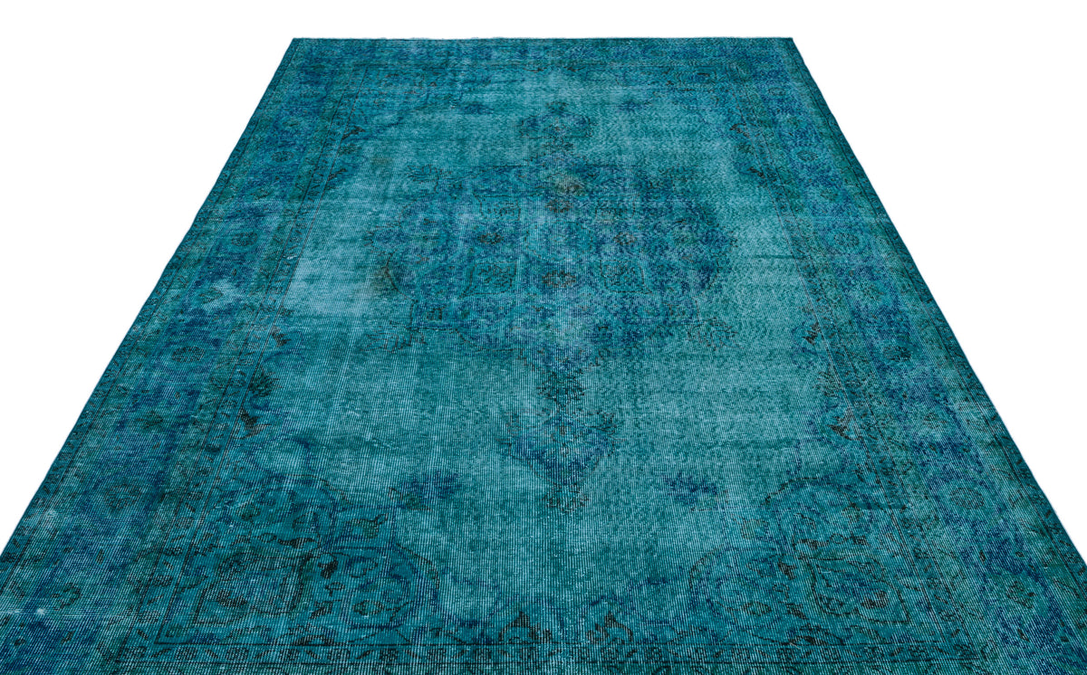 Teal distressed area rug with a traditional faded medallion pattern on a white background.