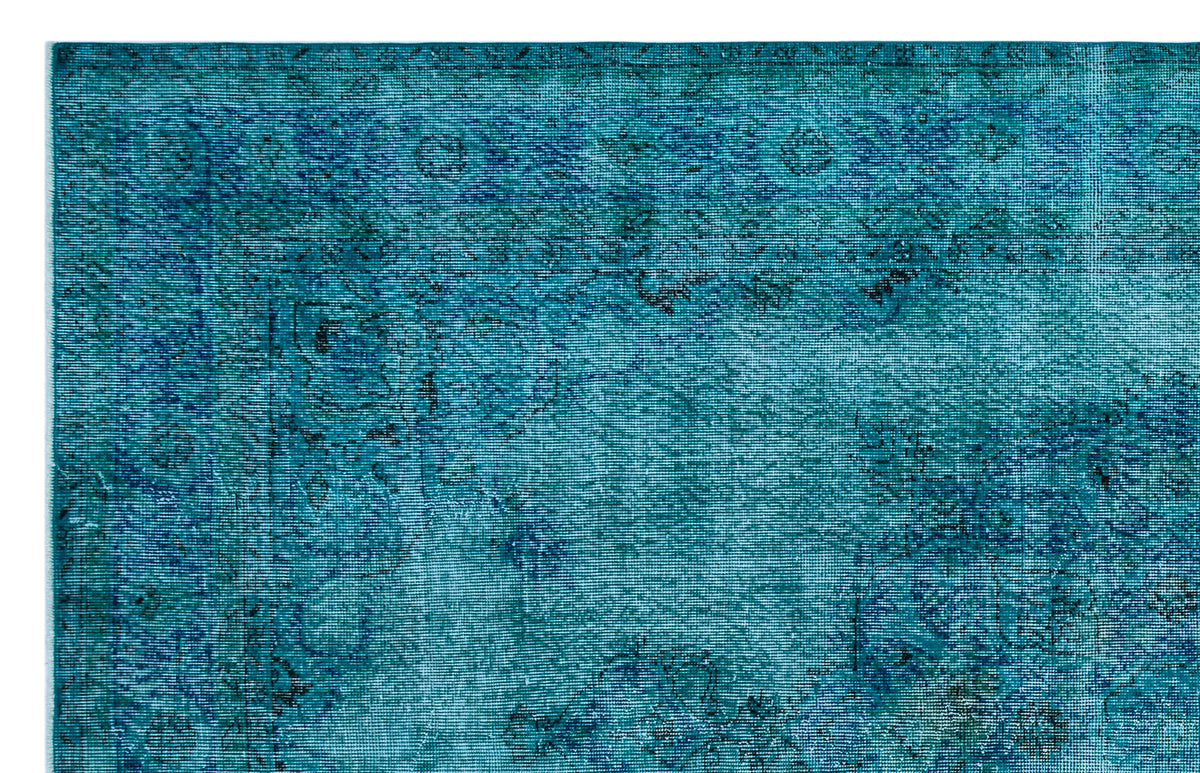 Teal and navy blue distressed rug with a traditional Persian-style border and faded floral medallion pattern.