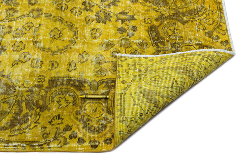 Load image 1 in gallery view. Mustard yellow and olive green distressed traditional rug with a floral medallion pattern, corner folded over.