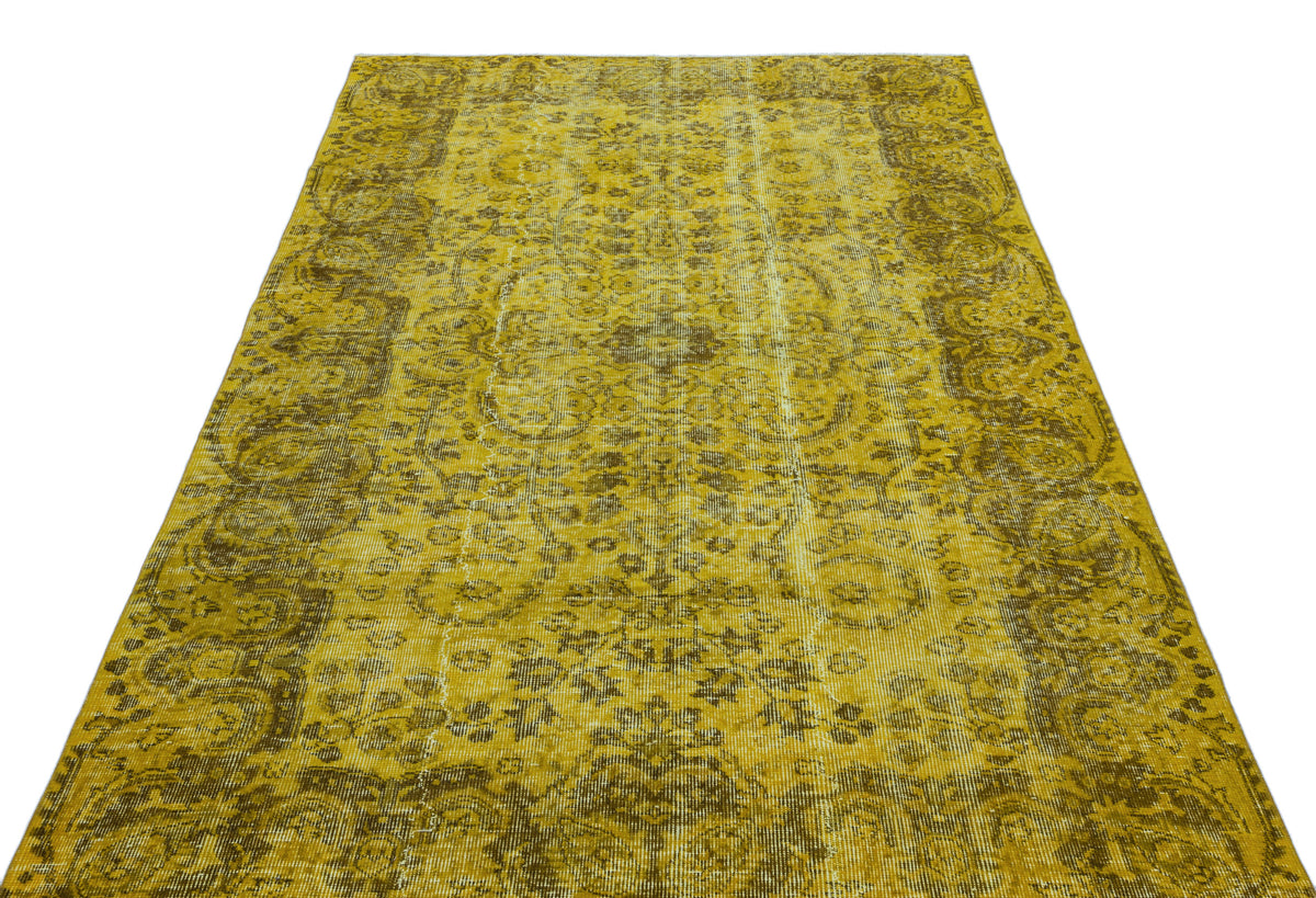 Mustard yellow and brown distressed vintage-style rug with a traditional floral medallion pattern.