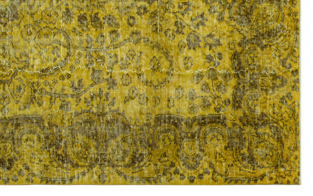 Mustard yellow and olive green distressed rug with an intricate traditional floral medallion pattern.