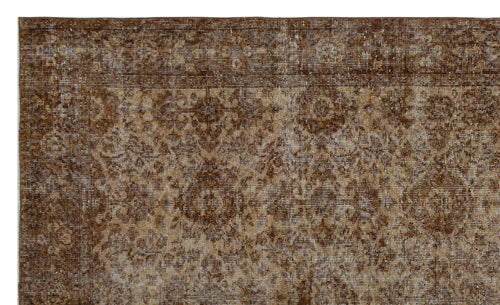 Load image 1 in gallery view. Dark brown and tan distressed rug with a traditional floral medallion pattern and a wide decorative border.