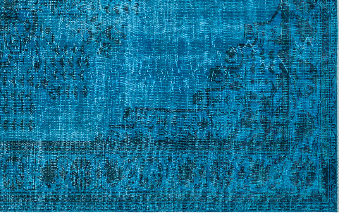 Bright blue distressed rug with a dark navy traditional floral medallion pattern and a detailed border.