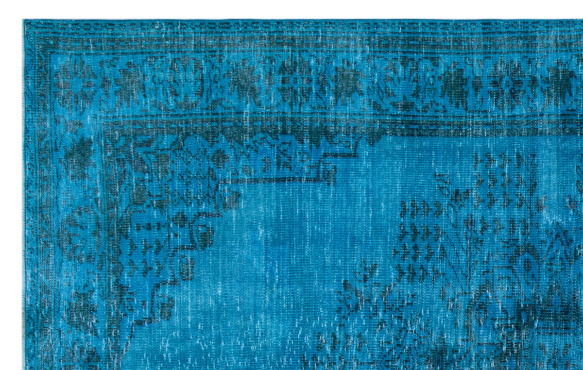 Bright blue distressed rug with a dark navy traditional floral border and central medallion pattern.