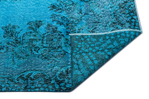 Load image 1 in gallery view. Bright turquoise and black distressed floral medallion rug with a folded corner showing the woven backing.