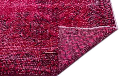 Load image 1 in gallery view. Magenta and dark red distressed floral rug with a folded corner showing the underside texture on a white background.