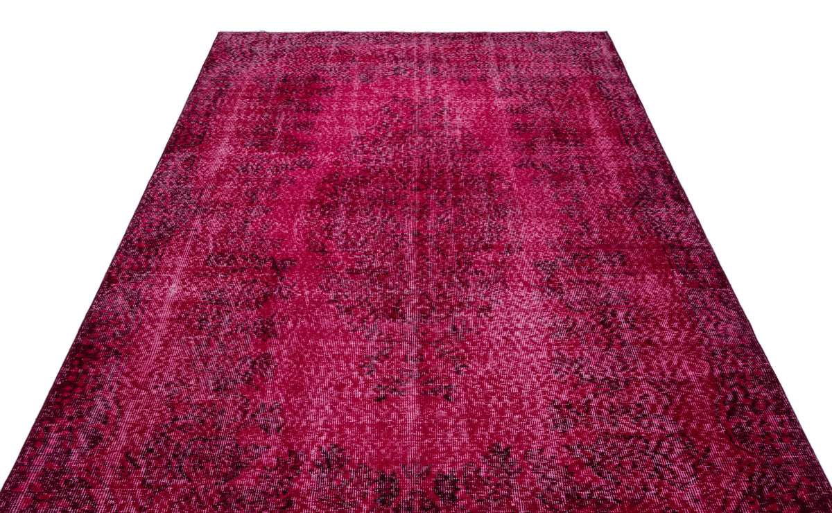 Magenta and dark red distressed vintage-style rug with a faded central medallion pattern on a white background.