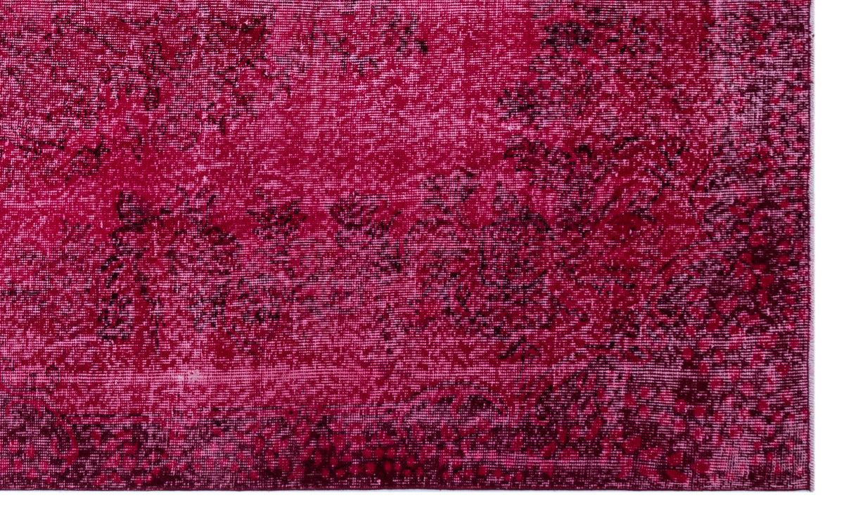 Magenta and black rug with a distressed, faded traditional floral pattern.