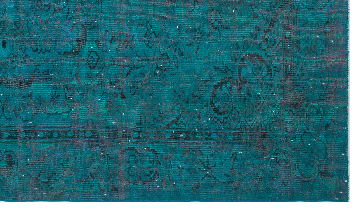 Teal rug with a distressed, dark grey traditional floral pattern and a geometric border.