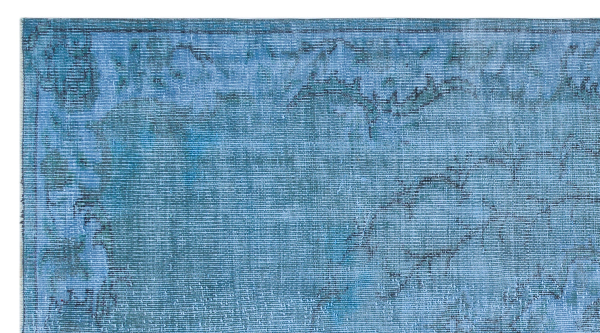 Blue distressed vintage-style rug with a faded traditional border and abstract worn texture.