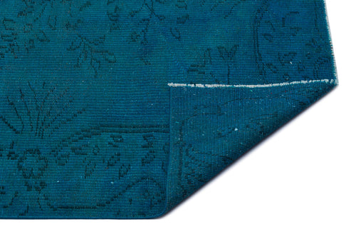 Load image 1 in gallery view. Teal rug with a subtle, dark floral pattern and a folded corner revealing the woven texture on a white background.