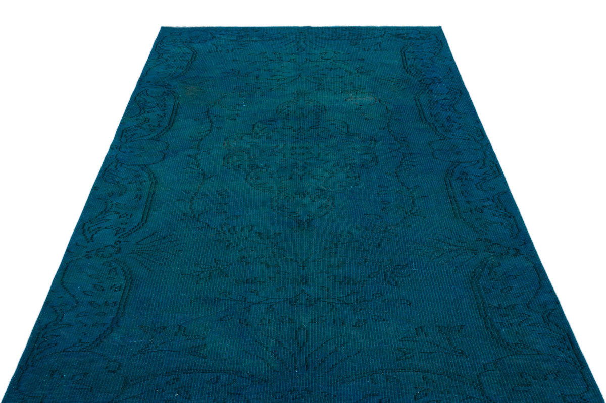 Deep teal vintage-style rug with a subtle, dark-toned traditional medallion and floral border pattern.