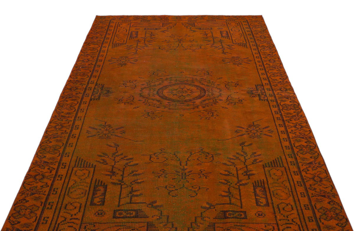 Burnt orange traditional rug with a central medallion and dark brown geometric border patterns on a white background.