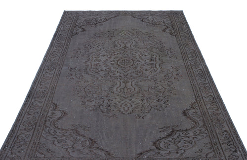 Load image 1 in gallery view. Dark charcoal and brown distressed rug with a traditional central medallion and ornate border pattern.