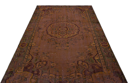 Load image 1 in gallery view. Distressed rust-brown vintage rug with a central floral medallion and ornate border patterns on a white background.