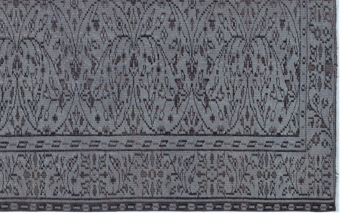 Charcoal and grey rug with a repeating damask-inspired pattern and a geometric border.