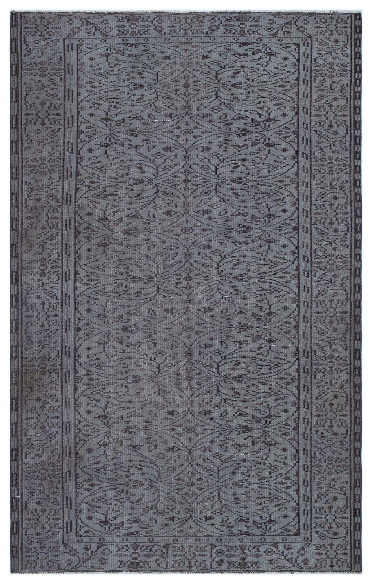 Charcoal grey rug with a repeating botanical trellis pattern and a geometric border on a white background.