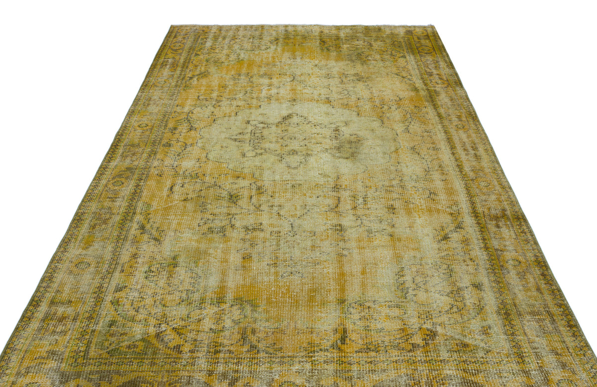 Distressed mustard yellow and beige vintage-style rug with a central medallion and ornate border.