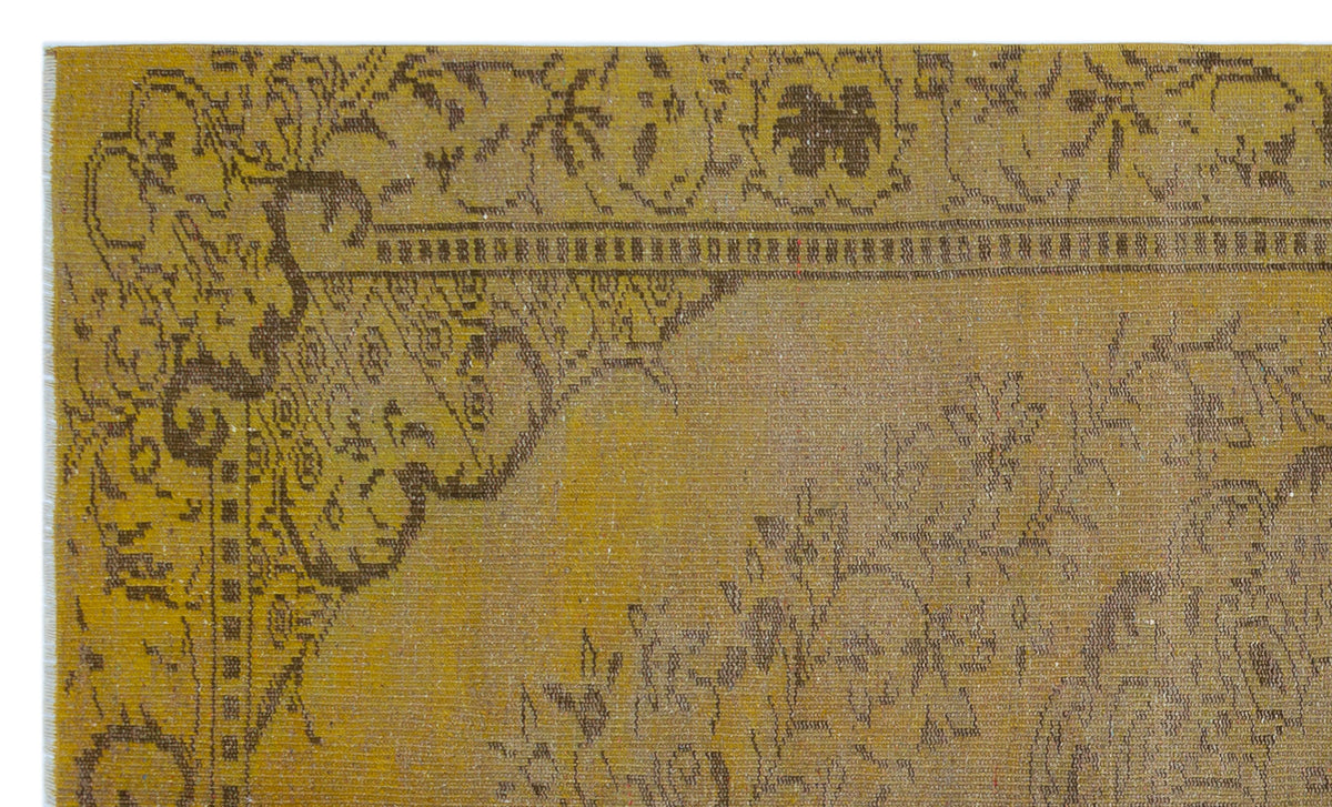 Mustard yellow vintage-style rug with a dark brown distressed floral medallion pattern and a decorative border.