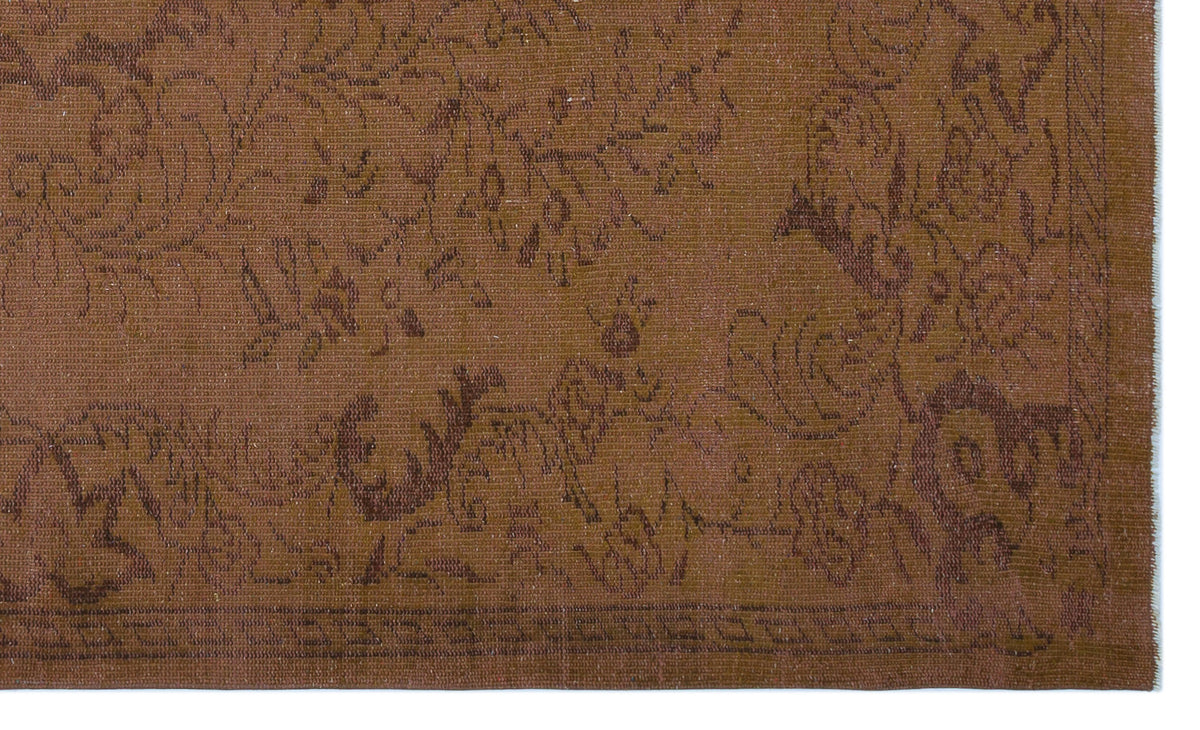 Monochromatic brown rug with a subtle, tone-on-tone floral damask pattern and a geometric border.