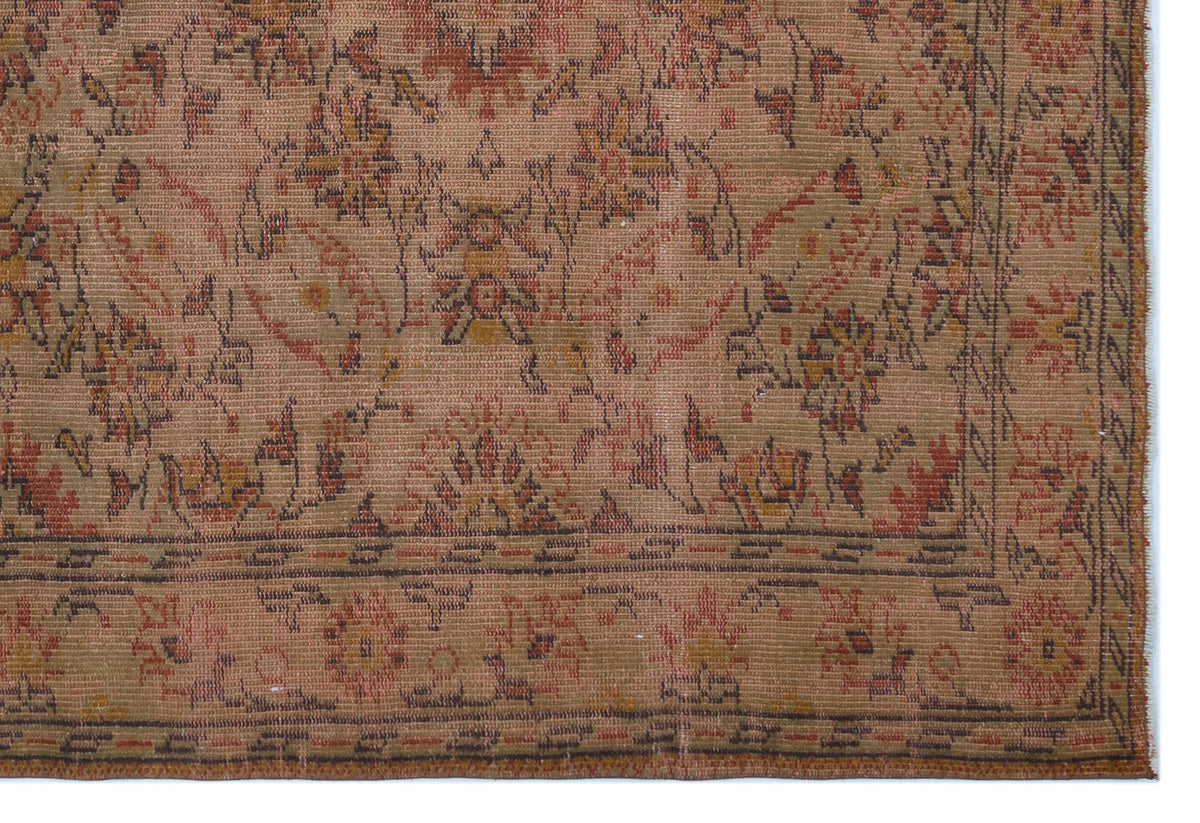 Distressed tan rug with a faded floral medallion pattern in rust, olive, and charcoal, featuring a detailed border.