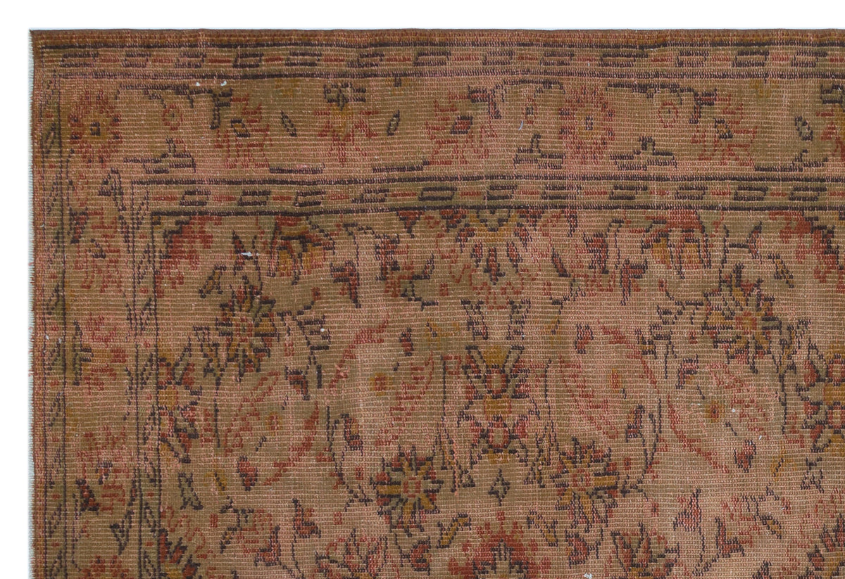 Rust and brown vintage-style rug with a faded floral medallion pattern and a geometric border.