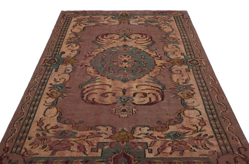 Load image 1 in gallery view. Brown traditional rug with a central green and tan floral medallion and ornate border patterns on a white background.