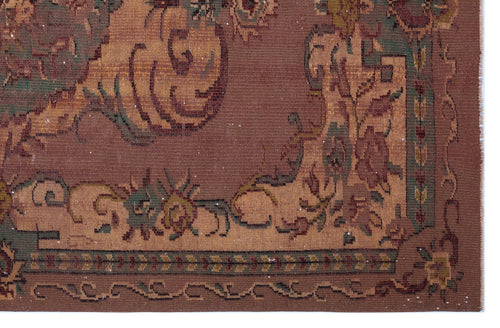 Load image 1 in gallery view. Brown traditional rug with a tan border and intricate floral and vine motifs in muted green and rust tones.