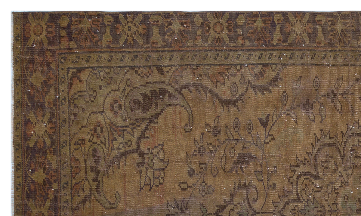 Brown and olive green vintage-style rug with a distressed traditional floral medallion pattern and ornate border.